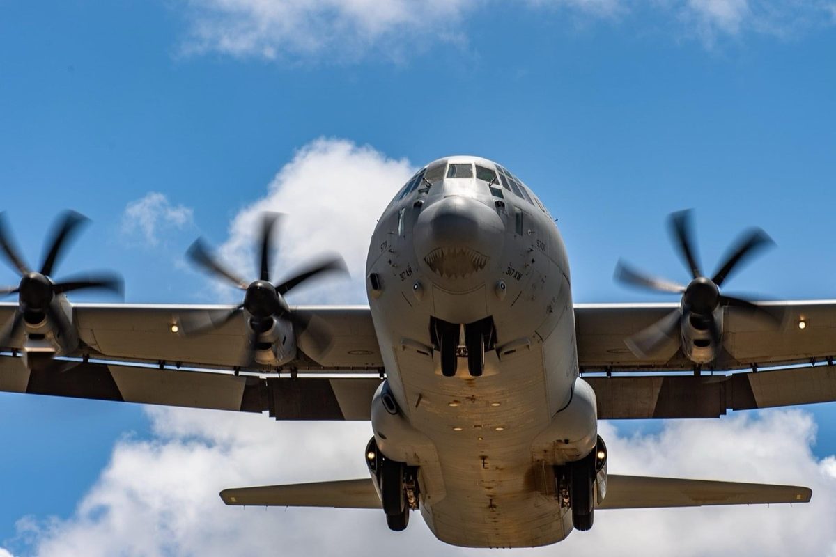C-130J Hercules seen head-on from below in flight against a blue sky