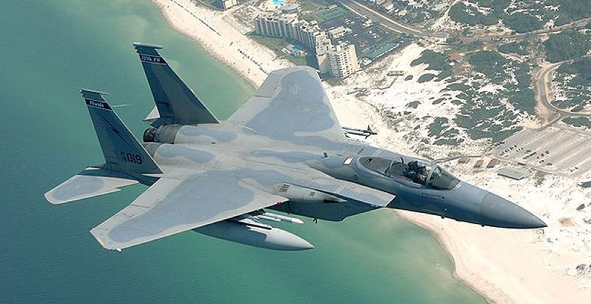 F-15 Eagle fighter jet flying over a Florida coastline